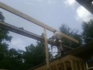 Carpenter setting a ridge beam over a new addition frame — Ice Dam Removal by Roofing Brothers in Birchwood