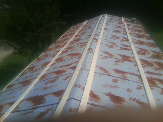 Rusted metal roof panels with new wood purlins before replacement — Storm Damage Roof Repair in Birchwood by Roofing Brothers