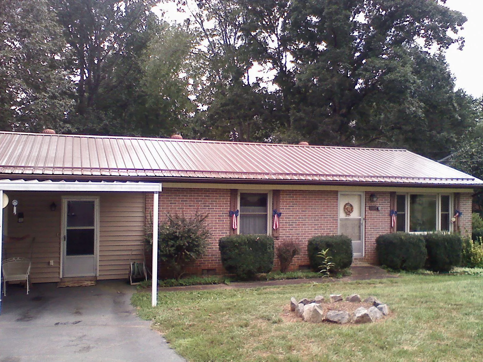 Bronze metal roof and carport on a brick ranch home — Roof Repair work by our crew in Birchwood