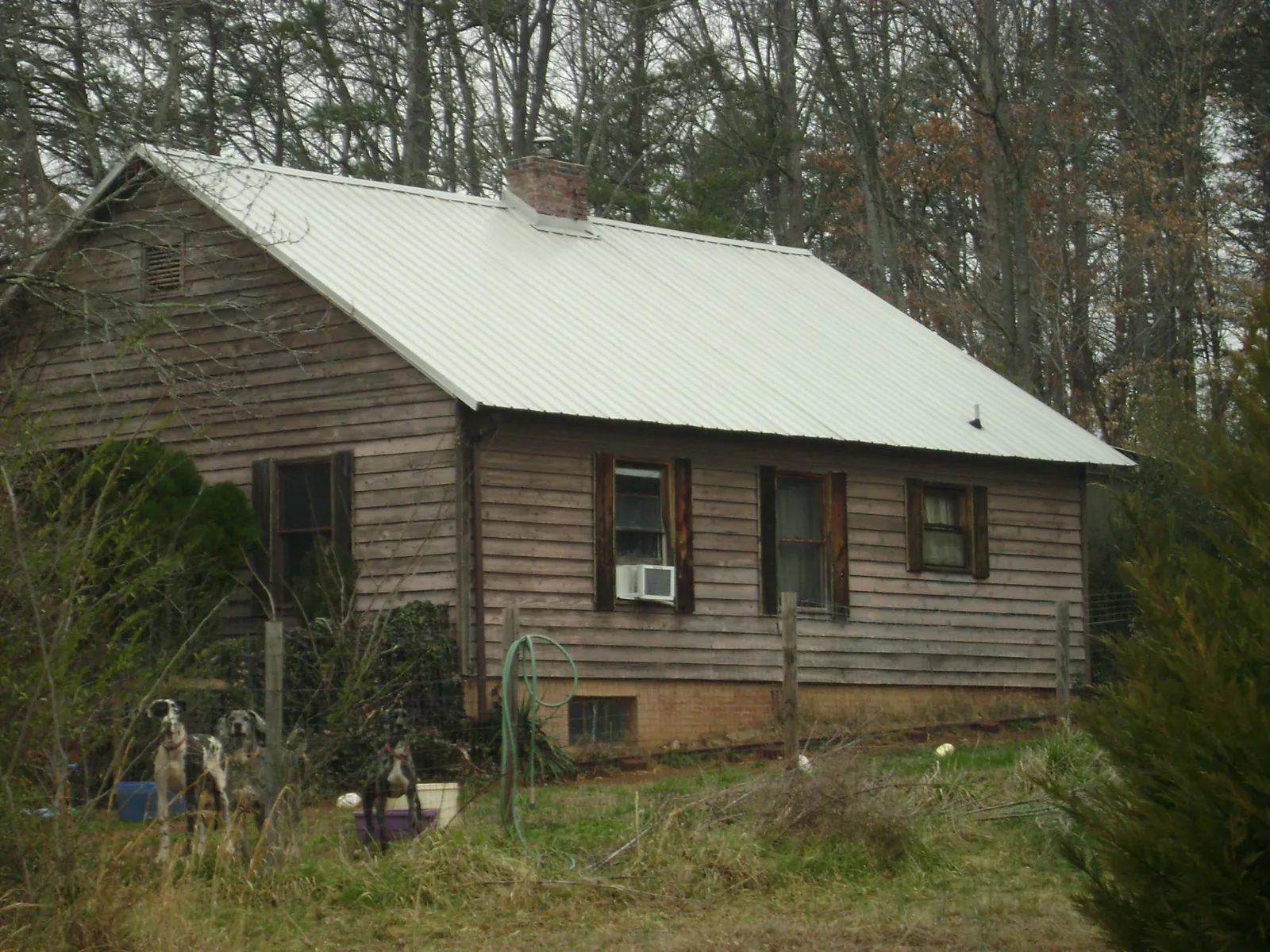 White metal roof on an old wood sided farmhouse, from a Metal Roof Installation job in Birchwood